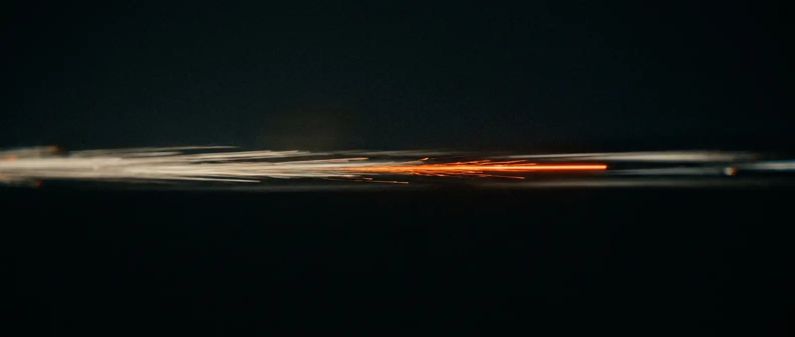Streaks of light blurred across black with one warm orange trail among them.